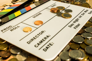 Clapper Board with coins and pennies scattered on it