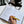 Open planner with task listings, hand holding a yellow pen, clapperboard, and camera in the background.