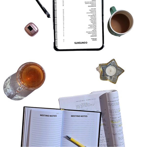 Flat lay of a notebook with 'Meeting Notes' pages, a tablet, a mug, and a candle on a white background.