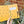 Yellow notebook with 'This book belongs to' tag held by a hand with plants in the background