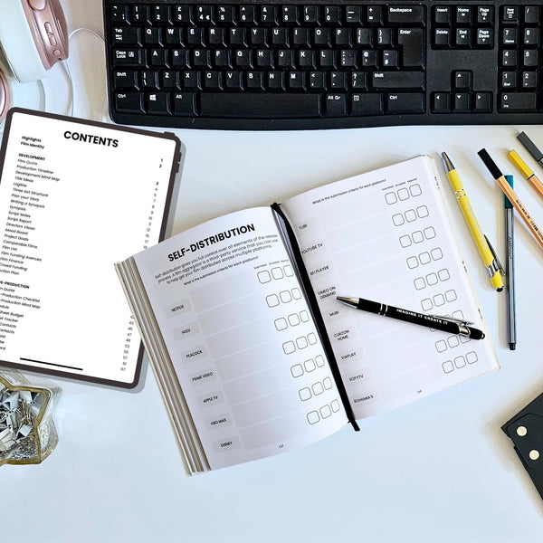Open notebook with checklists on a desk with a keyboard and stationery items.
