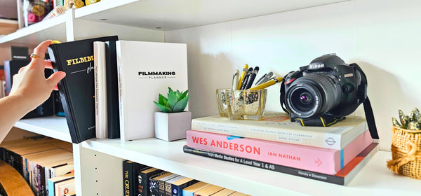 Bookshelf with books, a camera, and decorative items