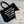 Black tote bag with motivational quote and beige notebook on a textured surface