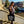 Woman holding a black bag with text, standing on steps outdoors.