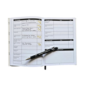 Open planner with a pen on a white background